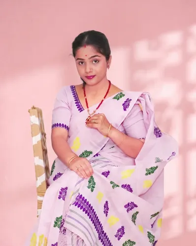 Light pink Kesa Paat Cotton mekhela sador set with purple, green, and yellow buta and dohi