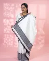 White Toss mekhela sador jura with black xoru buta, stitched black phulam pari, blouse piece, and stripe end
