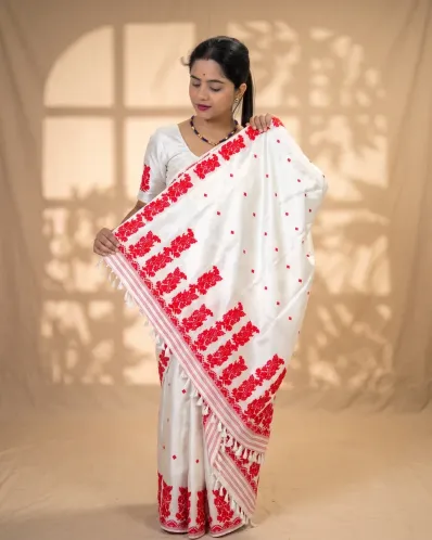 White Toss mekhela sador jura with red xoru phul buta, red modern phul, self pari, blouse piece, and white tassels