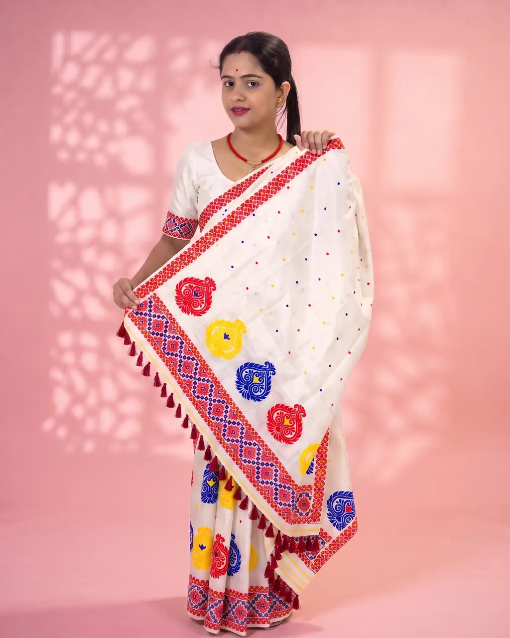 White Toss mekhela sador jura with colourful bindi buta, broad kalka phul lower-end design, and unstitched contrast pari